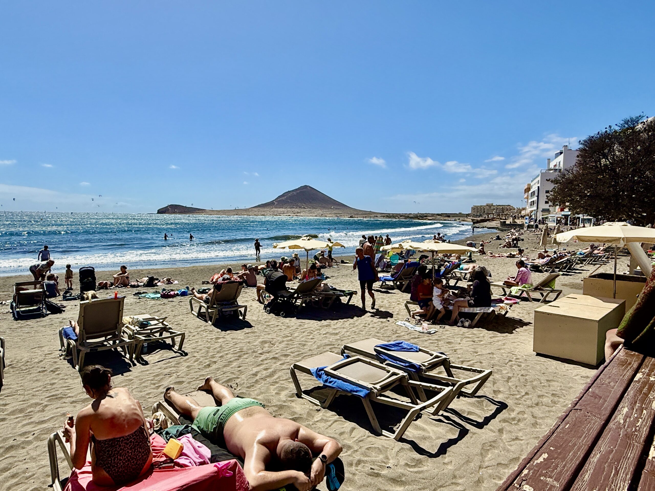 Sonniger Badetag am Playa El Médano mit Liegen und Blick auf Montana Roja